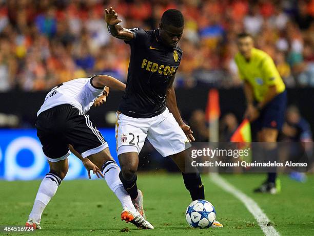 Elderson of Monaco is tackled by Sofiane Feghouli of Valencia during the UEFA Champions League Qualifying Round Play Off First Leg match between...