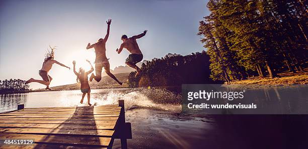 jumping into the water from a jetty - swimming stock pictures, royalty-free photos & images