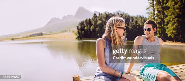 couple is flirting on a jetty - couple jetty stock pictures, royalty-free photos & images