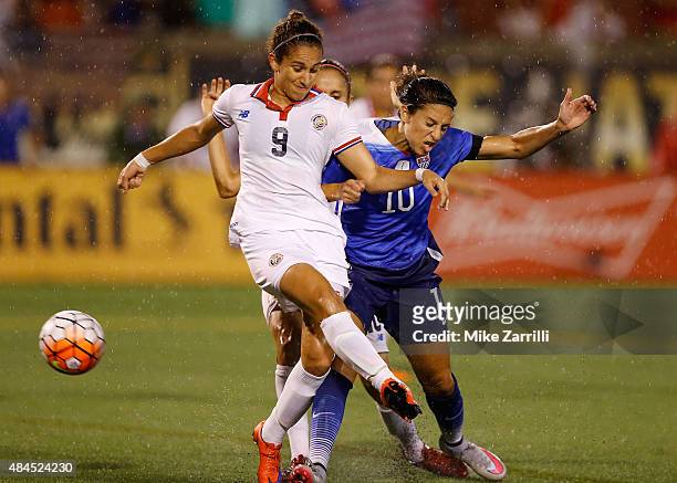 Midfielder Carli Lloyd of the United States shoots and scores in the first half behind defender Carolina Venegas of Costa Rica during the friendly...