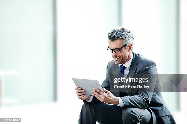 businessman using a tablet outside in the city. - business person on tablet stock pictures, royalty-free photos & images