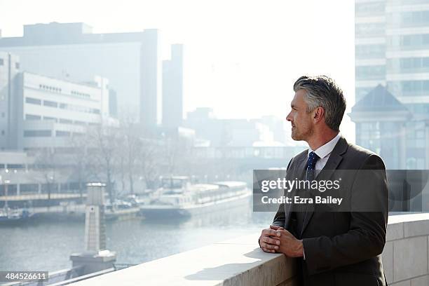 business man looking out over the city. - business reflection stock pictures, royalty-free photos & images