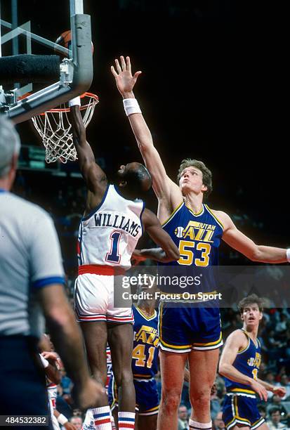 Mark Eaton of the Utah Jazz attempts to block the shot of Gus Williams of the Washington Bullets during an NBA basketball game circa 1985 at the...