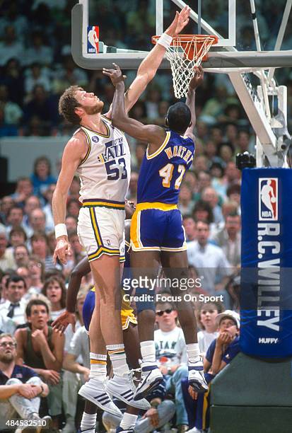 Mark Eaton of the Utah Jazz attempts to block the shot of James Worthy of the Los Angeles Lakers during an NBA basketball game circa 1989 at the Salt...