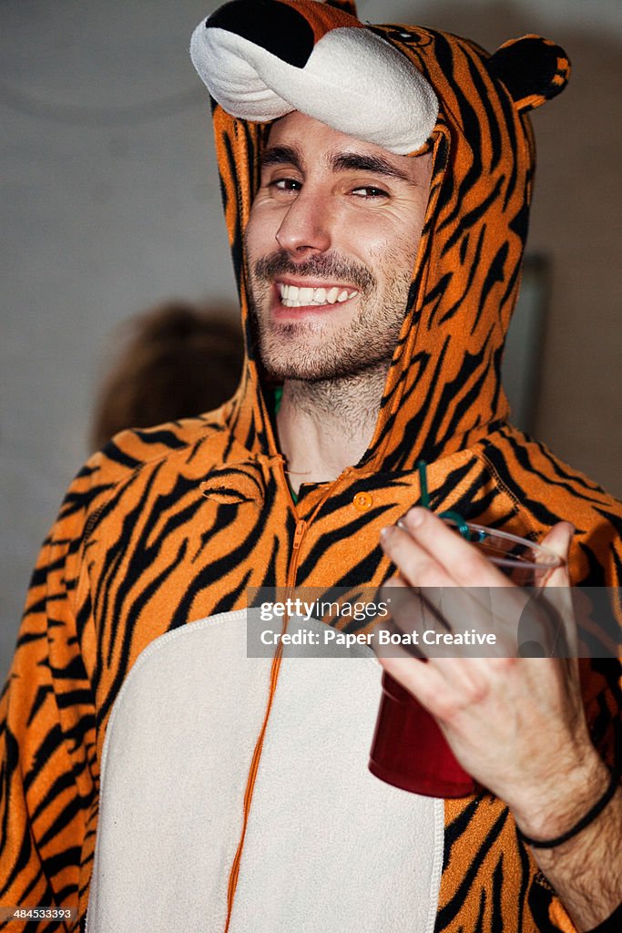 Man in a tiger onesie outfit in a student party