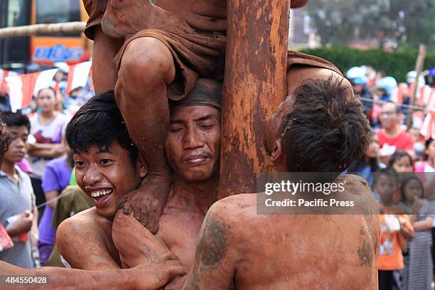 Participants compete for a prize in climbing a greased pole called Panjat Pinang as Indonesians celebrate the 70th National Independence Day....