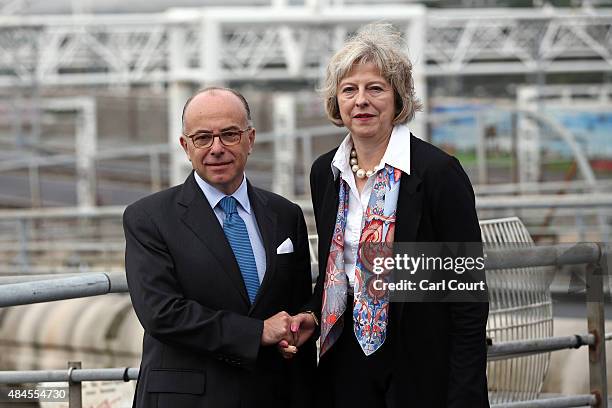 Britain's Home Secretary, Theresa May shakes hands with French Interior Minister Bernard Cazeneuve at the Eurotunnel Terminal on August 20, 2015 in...