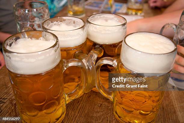 large beers on beer hall table - oktoberfest fotografías e imágenes de stock