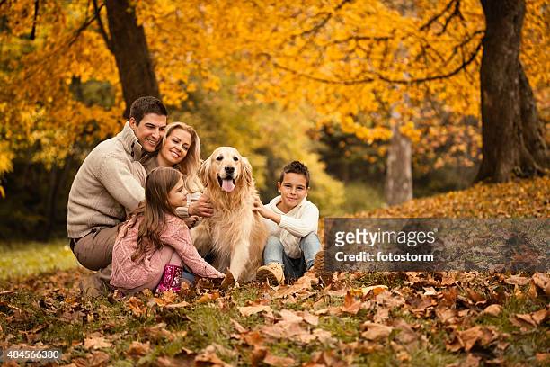 family and golden retriever in the park - four people stock pictures, royalty-free photos & images