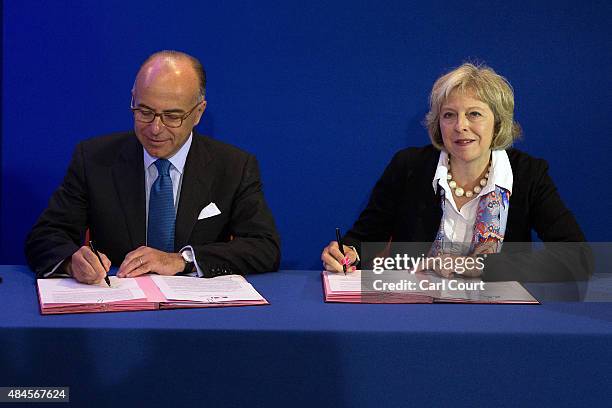 Britain's Home Secretary Theresa May and French Interior Minister Bernard Cazeneuve sign an agreement to tackle the migrant crisis in Calais on...