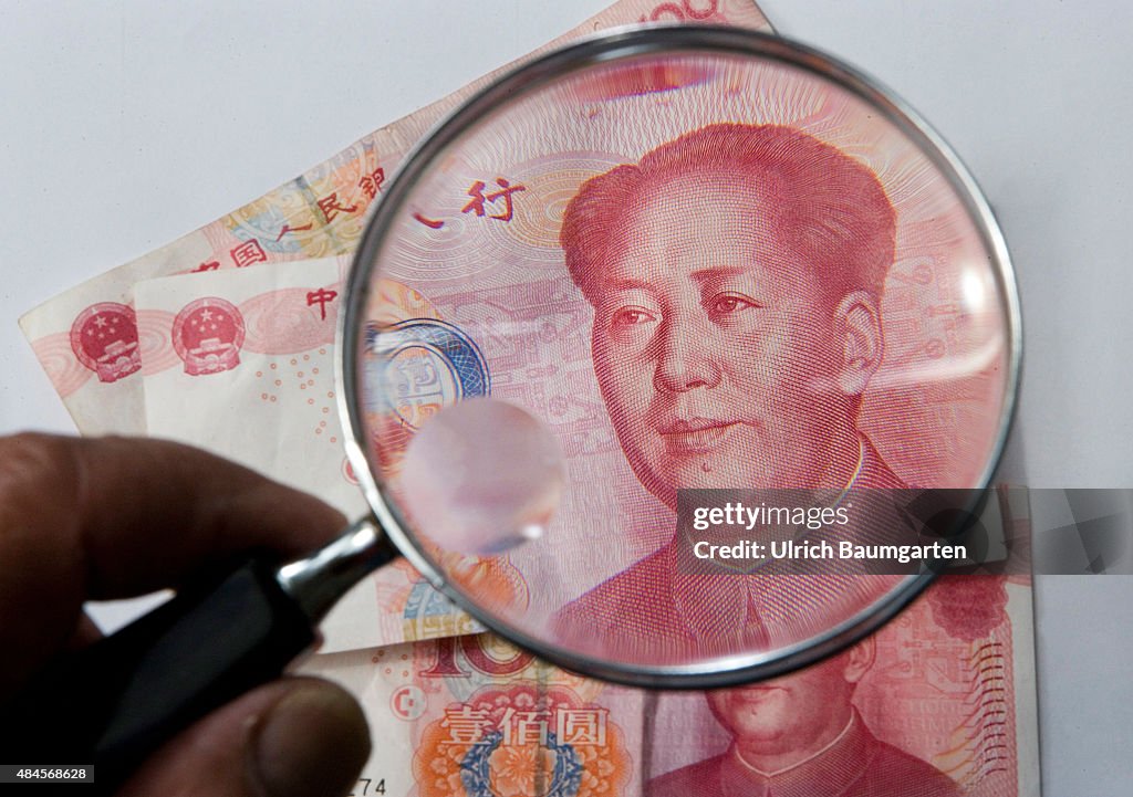 Chinese 100 yuan banknote under a magnifying glass.