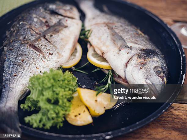 fish grill mit einer füllung aus zitrone und rosmarin - goldbrasse stock-fotos und bilder