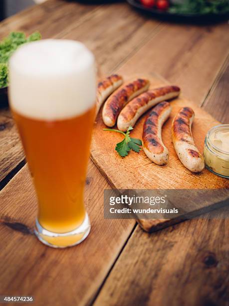 cold beer with grilled bratwurst sausages on a wooden table - oktoberfest germany stock pictures, royalty-free photos & images