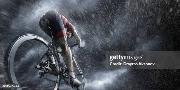 professional cyclist under stormy sky - uithoudingsvermogen stockfoto's en -beelden