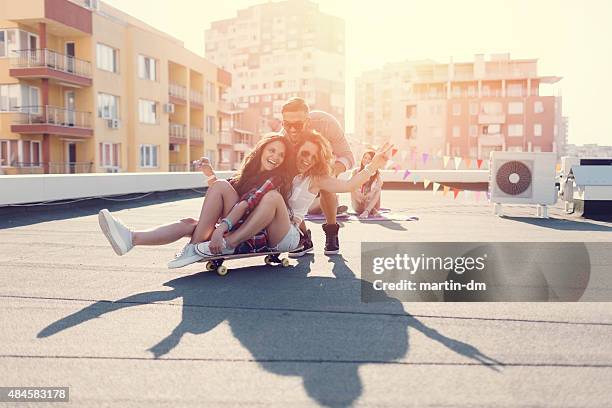 teenage girls skateboarding on the rooftop - city to surf stock pictures, royalty-free photos & images