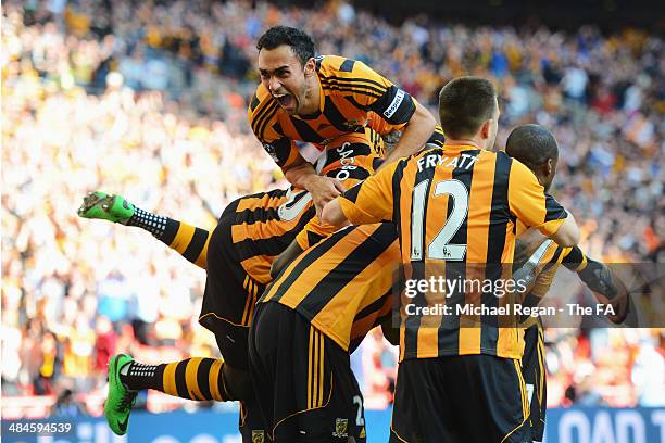 Ahmed Elmohamady and Yannick Sagbo of Hull City jump on top of their team-mate Tom Huddleston after he scored their third goal during the FA Cup...