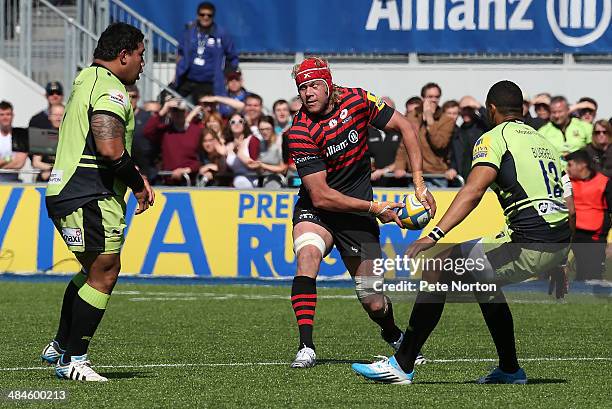 Mouritz Botha of Saracens looks to play the ball watched by Luther Burrell and Salesi Ma'Afu of Northampton Saints during the Aviva Premiership match...