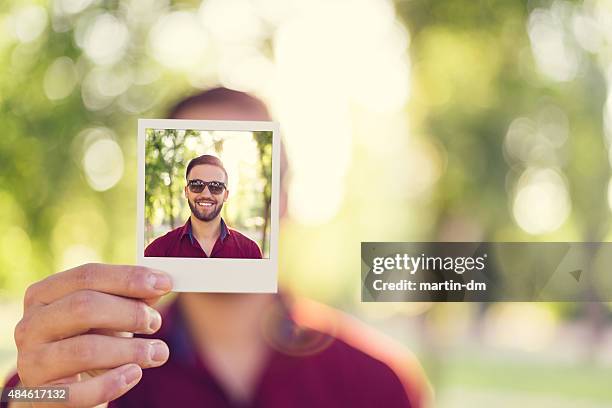 man holding instant selfie - guy with face in hands stockfoto's en -beelden