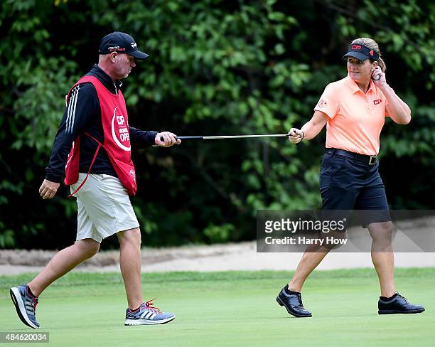 Lorie Kane of Canada hands over her putter to caddie Danny Sharp after saving par on the 12th green during the first round of the Canadian Pacific...