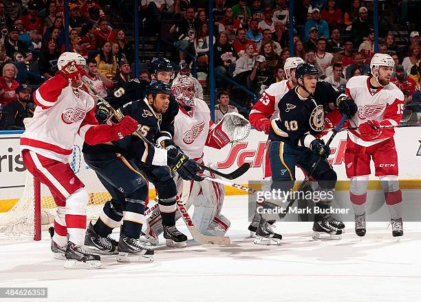 Maxim Lapierre, Magnus Paajarvi and Ryan Reaves of the St. Louis Blues crowd around goalie Petr Mrazek of the Detroit Red Wings as Riley Sheahan,...