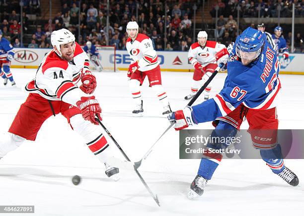 Jay Harrison of the Carolina Hurricanes attempts to block a shot taken by Benoit Pouliot of the New York Rangers at Madison Square Garden on April...