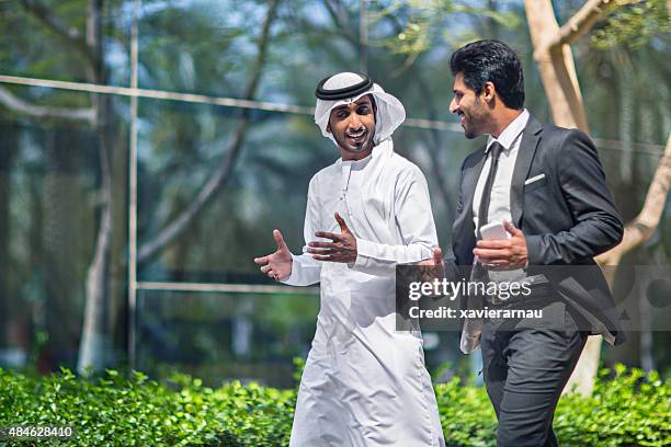 middle eastern businessmen talking in the street - emirate stockfoto's en -beelden