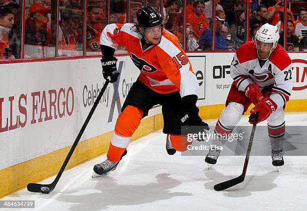 Tye McGinn of the Philadelphia Flyers wraps around the net as Manny Malhotra of the Carolina Hurricanes defends at Wells Fargo Center on April 13,...