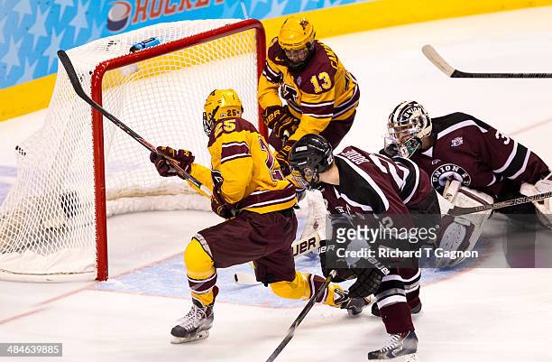 Justin Kloos of the Minnesota Golden Gophers scores against Colin Stevens of the Union College Dutchmen as teammate Taylor Cammarata is close by...