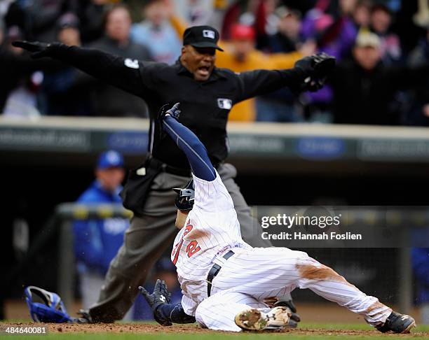 Brian Dozier of the Minnesota Twins looks on as home plate umpire Laz Diaz calls him safe during the eighth inning of the game against the Kansas...