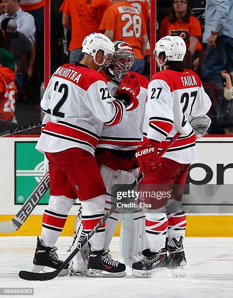 Anton Khudobin of the Carolina Hurricanes celebrates the win with teammates Manny Malhotra and Justin Faulk after the game against the Philadelphia...