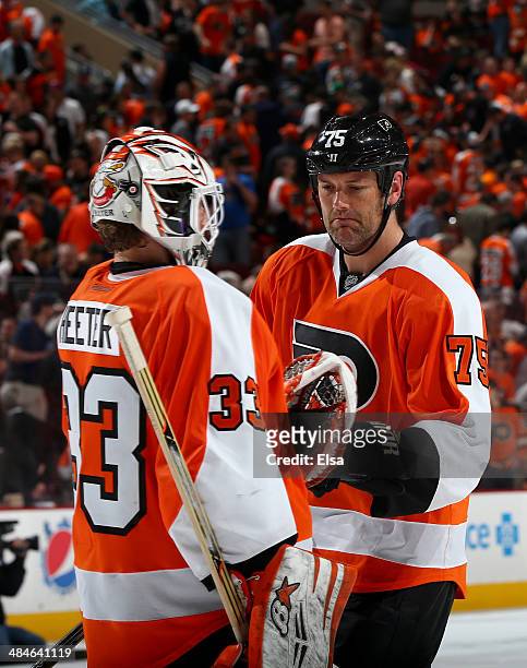 Hal Gill of the Philadelphia Flyers greets Cal Heeter after the overtime loss to the Carolina Hurricanes at Wells Fargo Center on April 13, 2014 in...