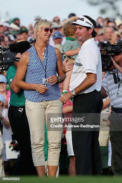 Bubba Watson of the United States waits with his wife Angie and their son Caleb on the 18th green after winning the 2014 Masters Tournament by a...