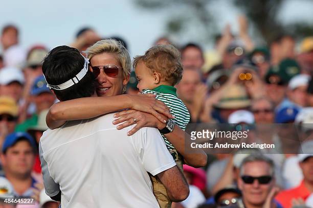 Bubba Watson of the United States celebrates with his wife Angie and their son Caleb on the 18th green after winning the 2014 Masters Tournament by a...