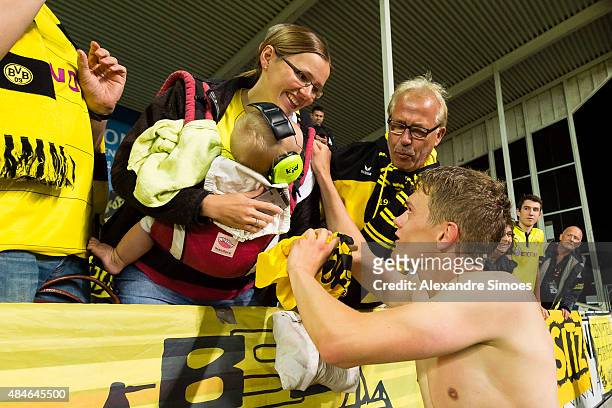 Matthias Ginter of Borussia Dortmund celebrates the win after the final whistle together with the fans and gives his shirt away during the UEFA...