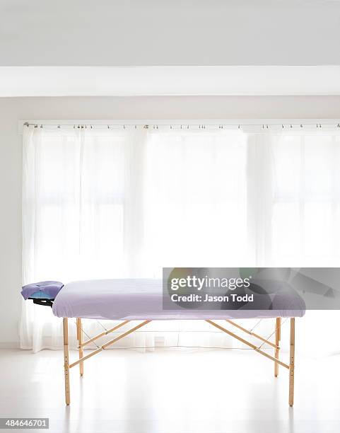 massage table in white room with curtain - massage table stock pictures, royalty-free photos & images