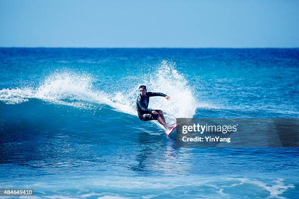 man on surfboard surfing in kauai, hawaii - surfer wetsuit stock pictures, royalty-free photos & images