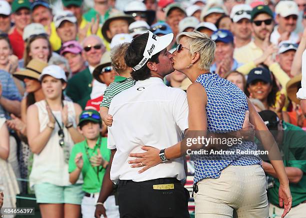 Bubba Watson of the United States celebrates with his wife Angie and their son Caleb on the 18th green after winning the 2014 Masters Tournament by a...