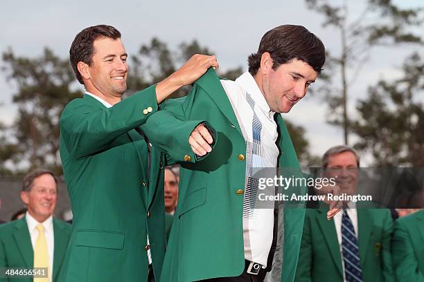 Adam Scott of Australia presents Bubba Watson of the United States with the green jacket after Watson won the 2014 Masters Tournament by a...