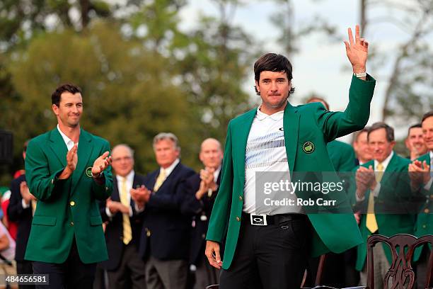 Bubba Watson of the United States poses with the green jacket after winning the 2014 Masters Tournament by a three-stroke margin as Adam Scott of...