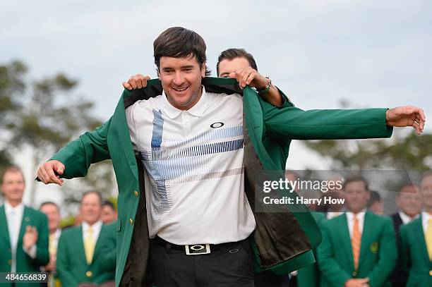 Adam Scott of Australia presents Bubba Watson of the United States with the green jacket after Watson won the 2014 Masters Tournament by a...