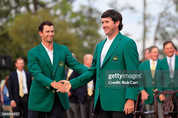 Adam Scott of Australia presents Bubba Watson of the United States with the green jacket after Watson won the 2014 Masters Tournament by a...