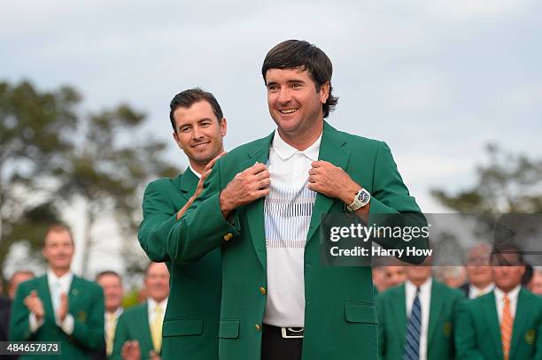 Adam Scott of Australia presents Bubba Watson of the United States with the green jacket after Watson won the 2014 Masters Tournament by a...