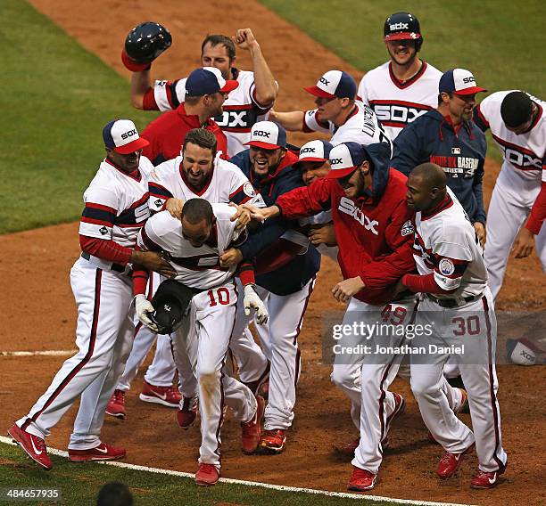 Alexei Ramirez of the Chicago White Sox is mobbed by teammates at home plate after hitting a two-run, walk-off home run in the bottom of the 9th...