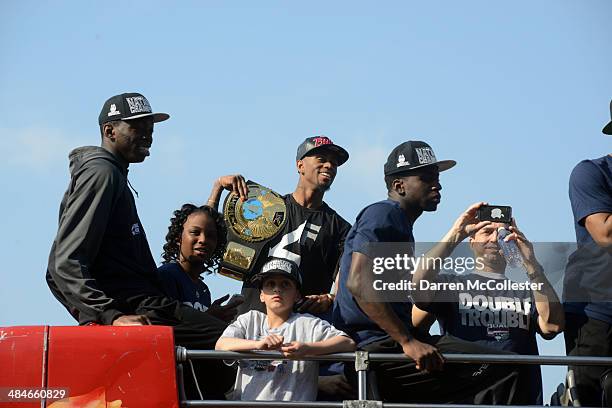 Members of the University of Connecticut men's basketball team ride in an open bus during a victory parade April 13, 2014 in Hartford, Connecticut....