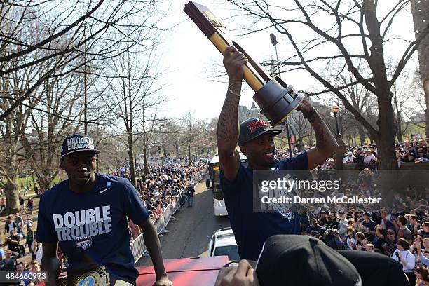 The University of Connecticut's Ryan Boatright holds the NCAA championship trophy along with teammate Amida Brimah as they ride in a victory parade...