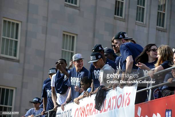 Members of the University of Connecticut men's basketball team ride in a victory parade to celebrate their national championship April 13, 2014 in...