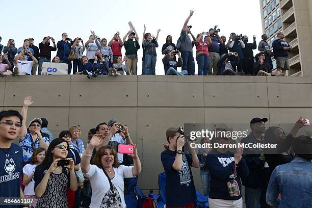 People line the parade route for the University of Connecticut's men's and women's basketball teams to celebrate their NCAA championships April 13,...