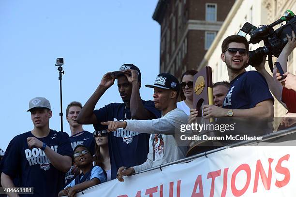 Members of the University of Connecticut men's basketball team ride in a victory parade to celebrate their national championship April 13, 2014 in...