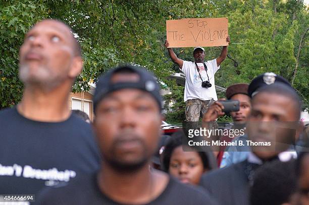 Man holds a sign during a candlelight vigil held in honor of Jamyla Bolden on August 20, 2015 in Ferguson, Missouri. Jamyla Bolden was allegedly...
