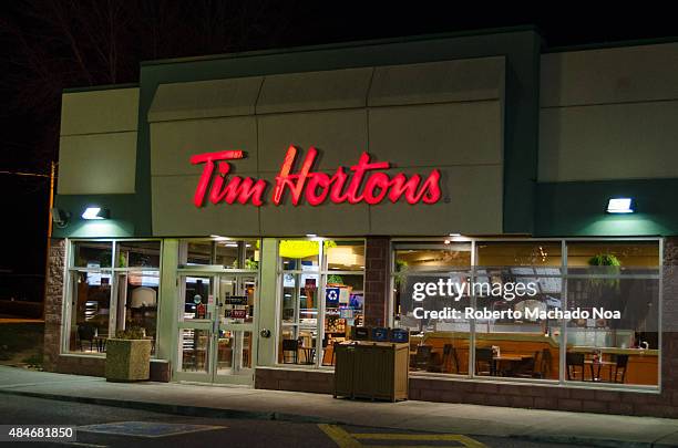 Tim Horton's restaurant during a Winter night with snow. Tim Hortons Inc is a Canadian multinational fast casual restaurant known for its coffee and...